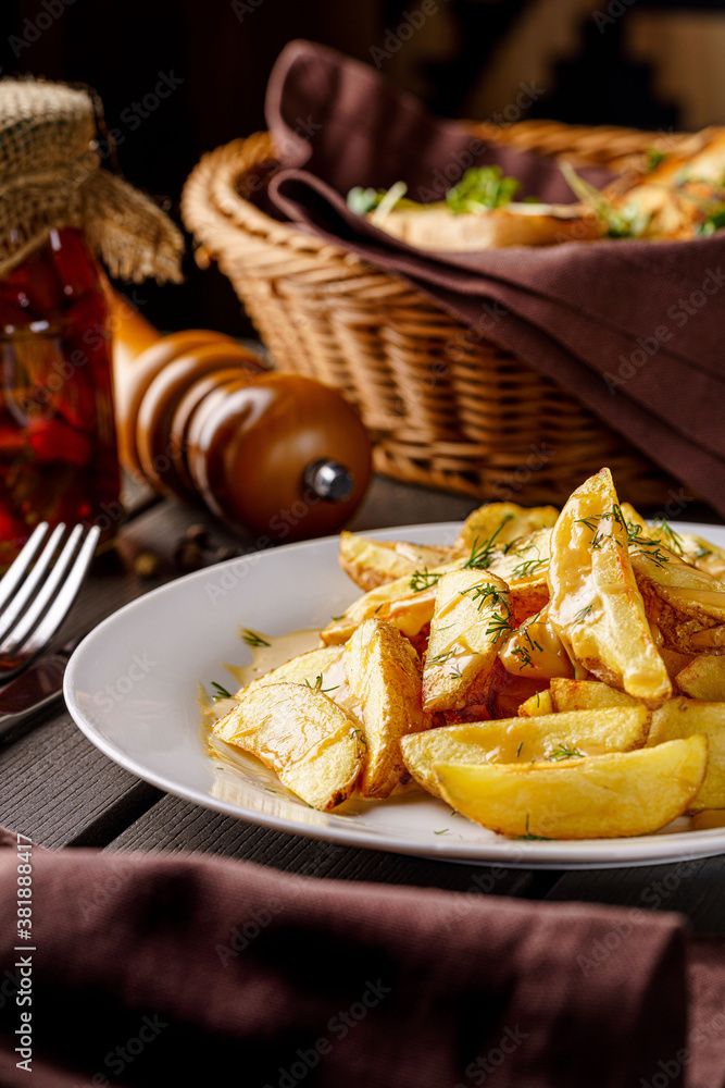 Country style potatoes with melted cheese. Serving food in a restaurant on a white plate. Background image. Country style potatoes with melted cheese. Serving food in a restaurant on a white plate. Background image.