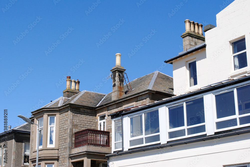 Varied Roof Line & Chimneys on Old Buildings against Blue sky 