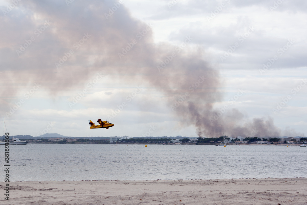 Fototapeta premium S'Albufera, Angry fire in S´Albufera in Mallorca, Balears, 26th September 2020, Alcudia, airplan under sea, the plane puts out the fire in Majorca, Spain, the area between Muro and Can Picafort