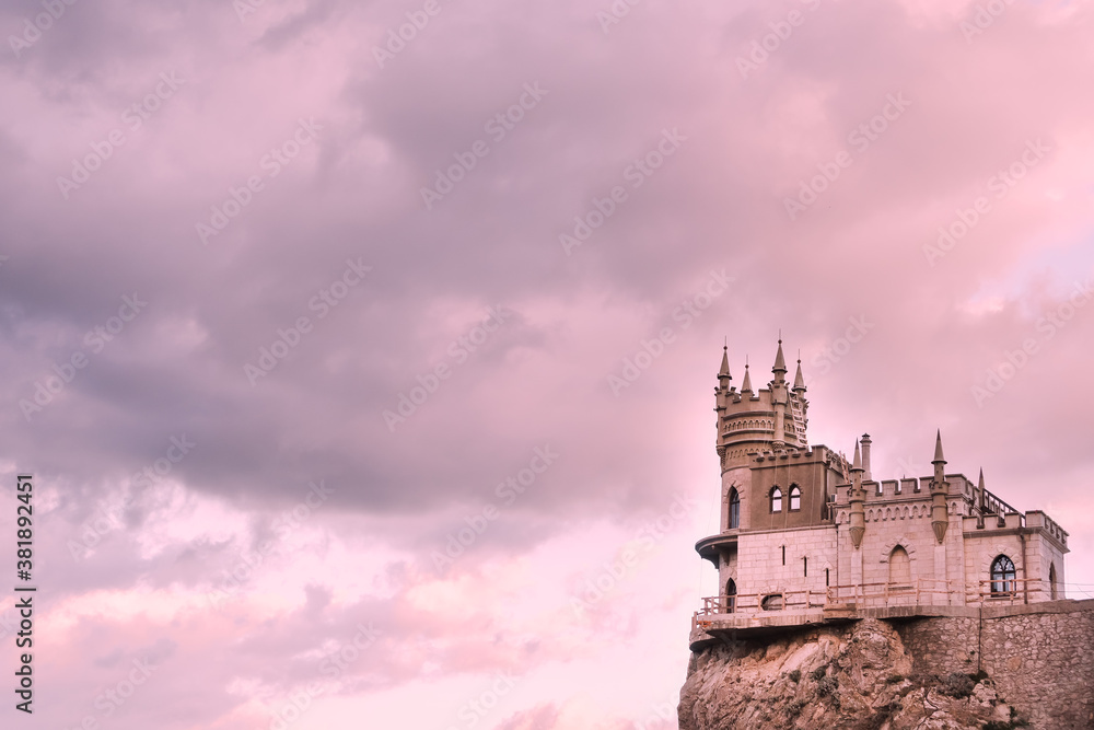 Swallow's nest Castle on a rock in the Black sea against the background of evening clouds, in pink tinting.