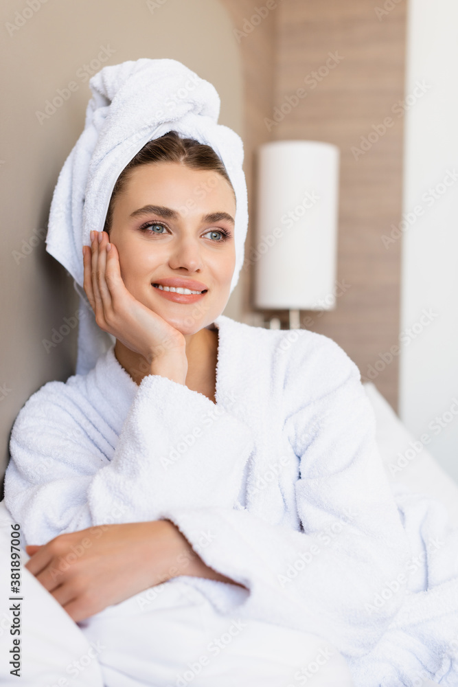 dreamy woman in towel and white bathrobe looking away in hotel room dreamy woman in towel and white bathrobe looking away in hotel room