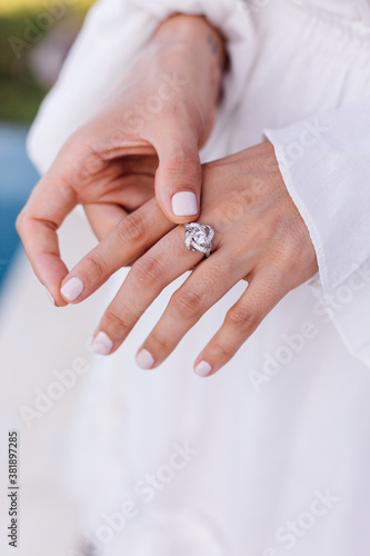 Close outdoor shot of womans hands wearing ring.