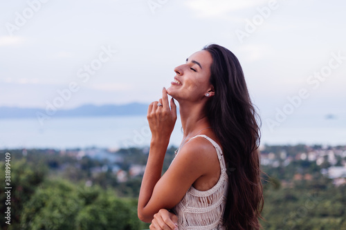 Portrait of happy caucasian calm romantic woman in casual look with long hair wearing earings and necklace on background amazing beautiful view on green mountains 