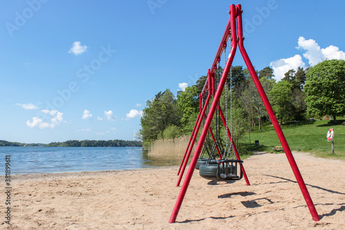 Red swings on the beach