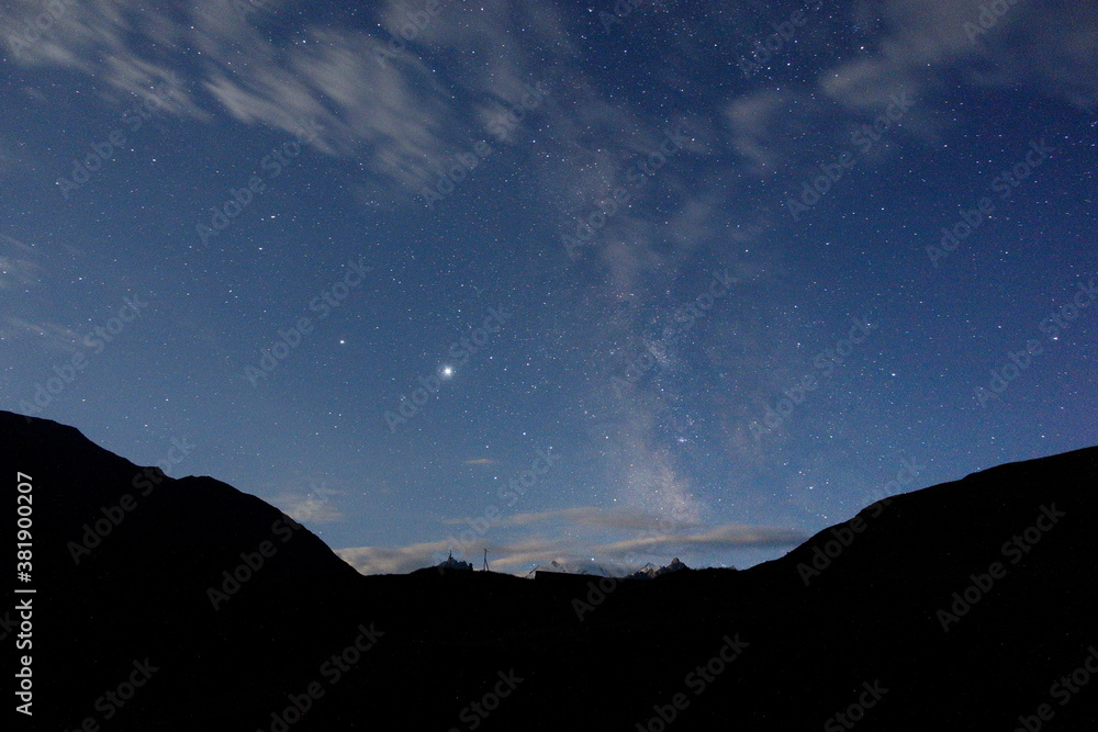Starry sky and milky way in the mountains. Mountain village against the background of the night starry sky and the milky way.