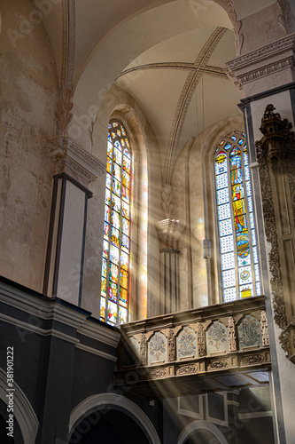 Rays of light shine through the stained glass of the catholic church