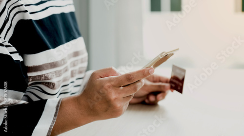 Businesswoman hand holding smartphone and credit card to online shopping from home, payment ecommerce, internet banking, spending money for next holidays