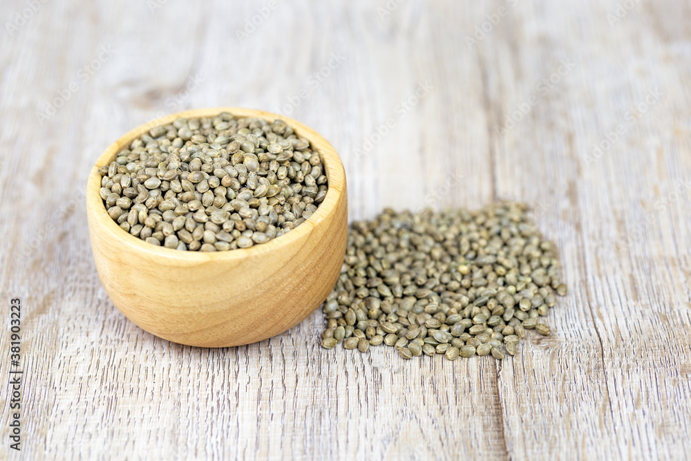 Cannabis seeds in a wooden cup Treatment ideas using cannabis oil, alternative medicine, space to place a message. Cannabis seeds in a wooden cup Treatment ideas using cannabis oil, alternative medicine, space to place a message.