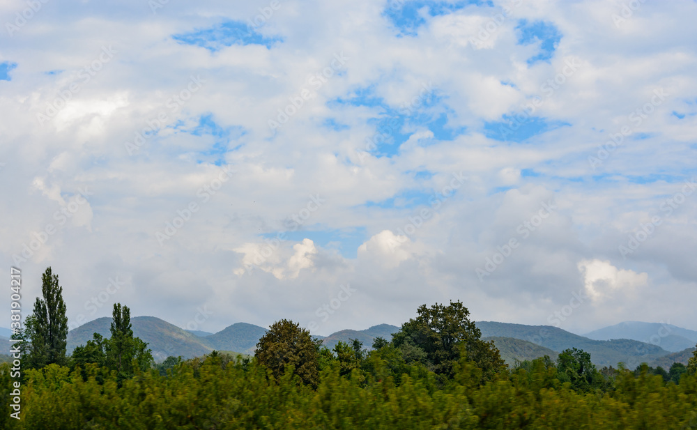 Beautiful mountain range in summer against a blue sky with clouds. blurry focus