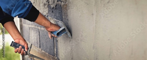 Concrete plasterers to create industrial workers background walls with plastering tools. photo