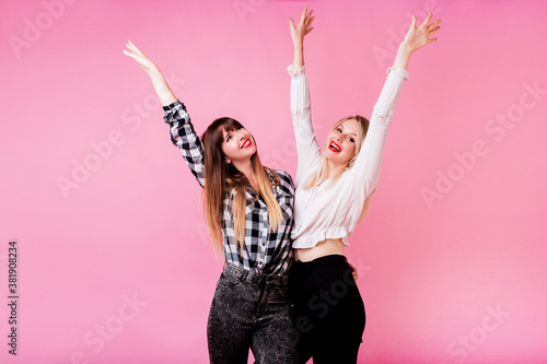 Canvas-taulu Two exited woman having fun and  raising hands up