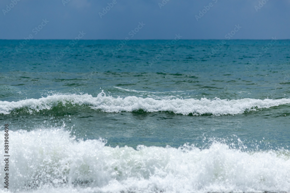 wave on the turquoise sea, amid storm clouds