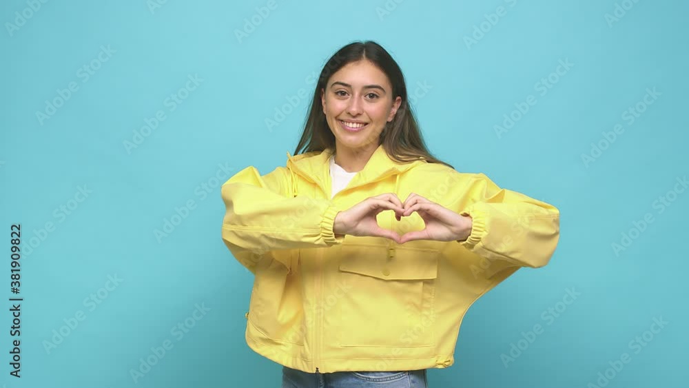 Young caucasian woman smiling and showing a heart shape with hands Young caucasian woman smiling and showing a heart shape with hands