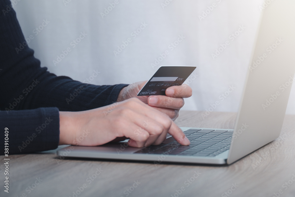 Hand holding credit card and using laptop. Online shopping concept