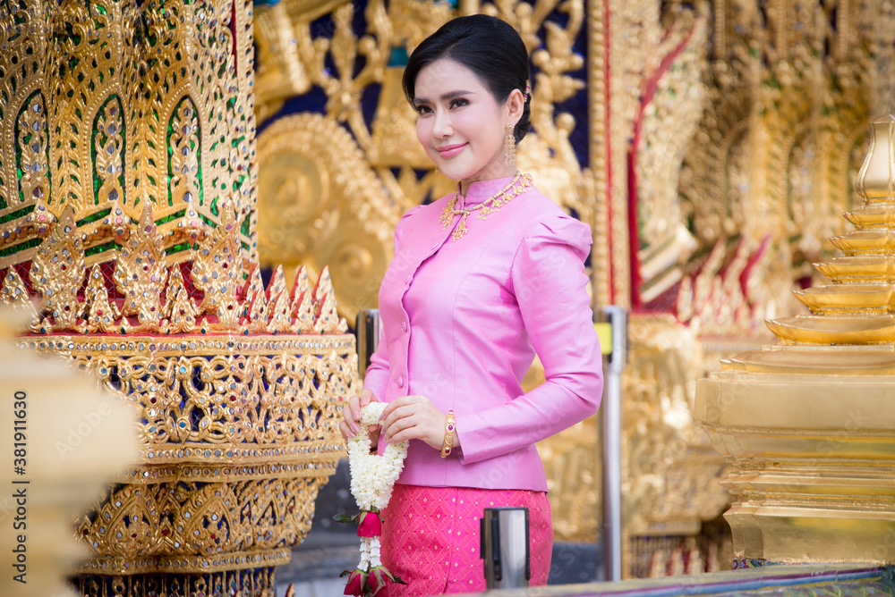 Portrait of a beautiful thai woman wearing a thai dress in a temple, Bangkok, Thailand