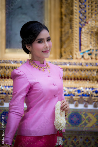 Portrait of a beautiful thai woman wearing a thai dress in a temple, Bangkok, Thailand