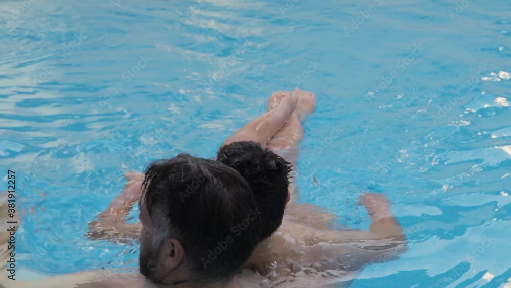 disabled child swims, relaxes and plays with his father in a pool. disabled child swims, relaxes and plays with his father in a pool.