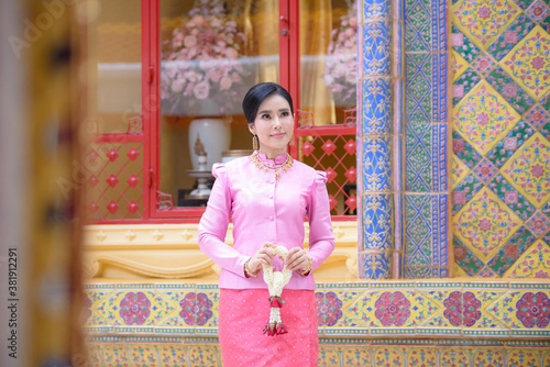 Portrait of a beautiful thai woman wearing a thai dress in a temple, Bangkok, Thailand © NITIKAN T.