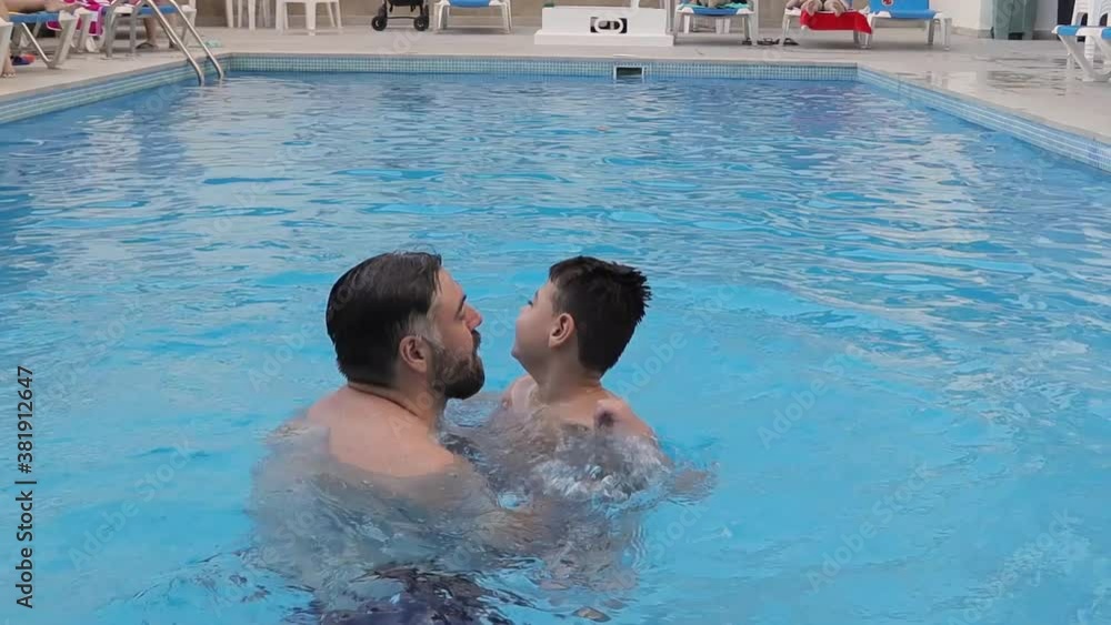 disabled child swims, relaxes and plays with his father in a pool. disabled child swims, relaxes and plays with his father in a pool.