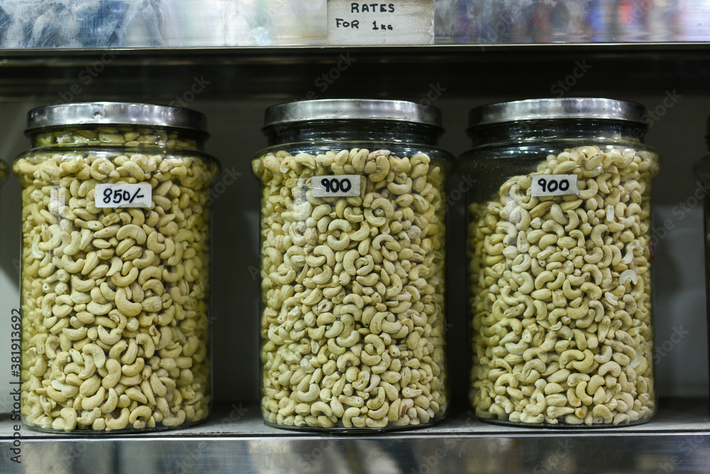 Cashew nuts in glass bottles. Raw and processed nuts Kerala, India. Whole, salted Anacardium occidentale seeds isolated food photo, close up. 