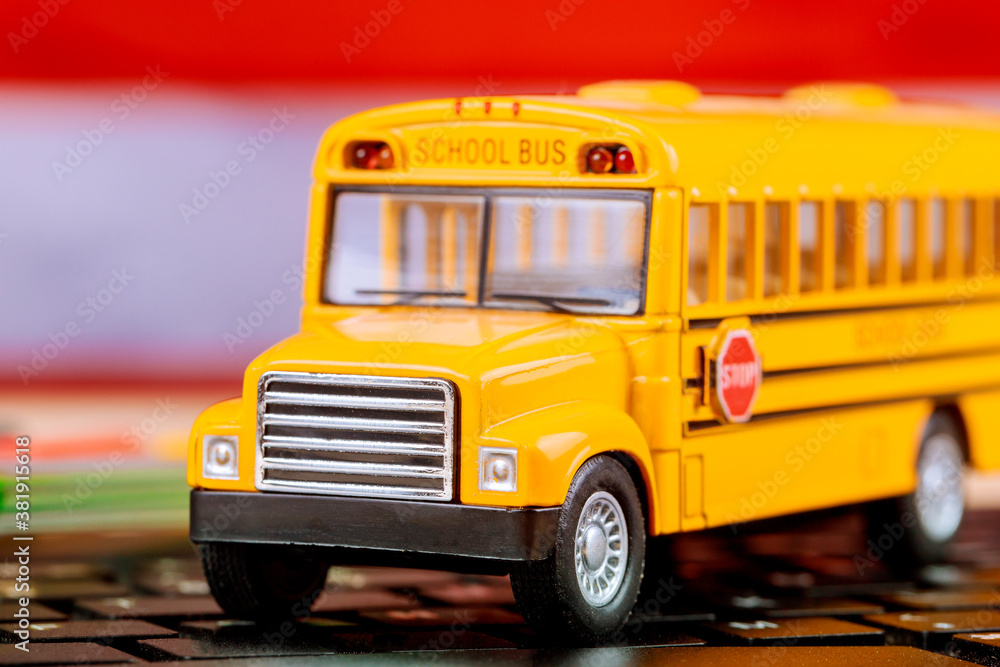 Online remote learning school with yellow school bus on laptop