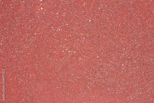 A wall of different types of stone and sand. Red texture background with some small white spots and dirt. Abstract art.