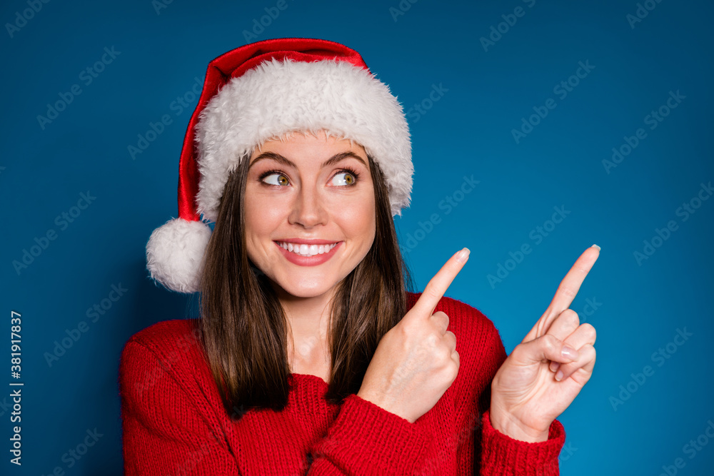 Close up photo positive girl in santa claus hat point index finger copyspace direct way x-mas christmas newyear ads promotion wear style stylish sweater isolated dark blue color background Close up photo positive girl in santa claus hat point index finger copyspace direct way x-mas christmas newyear ads promotion wear style stylish sweater isolated dark blue color background