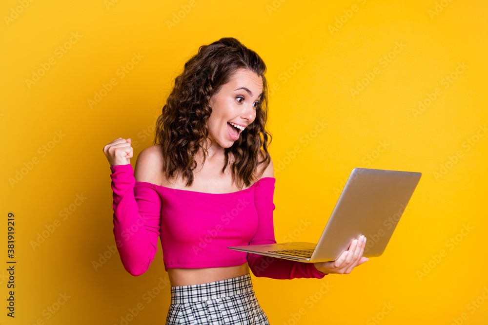 Photo of lady hold netbook cheerful amazed luck excited open mouth raise fist look screen wear pink top unclothed shoulders skirt isolated yellow color background Photo of lady hold netbook cheerful amazed luck excited open mouth raise fist look screen wear pink top unclothed shoulders skirt isolated yellow color background