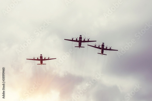 Fotobehang Three turboprop bombers fly in the gray sky.