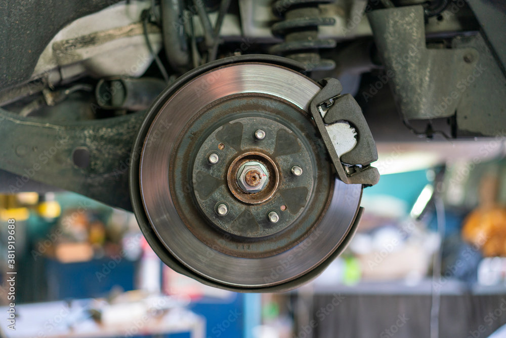 The hub of a wheel in a car service. Suspended car with no wheels. Suspension of car in service room.The car lift up by lifter for maintenance suspension and cleaning parts. Close up The hub of a wheel in a car service. Suspended car with no wheels. Suspension of car in service room.The car lift up by lifter for maintenance suspension and cleaning parts. Close up