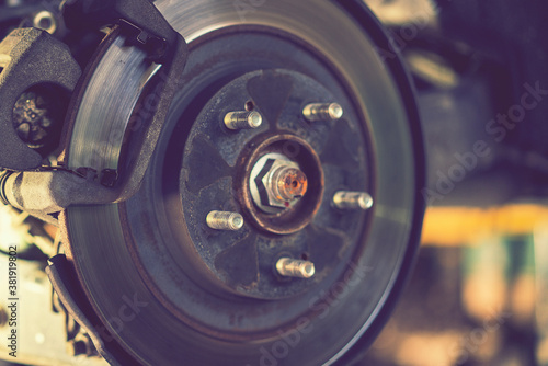 The hub of a wheel in a car service. Suspended car with no wheels. Suspension of car in service room.The car lift up by lifter for maintenance suspension and cleaning parts. Close up. toned