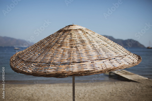 Fototapeta Naklejka Na Ścianę i Meble -  Bamboo beach umbrella on the background of the sea, beach.