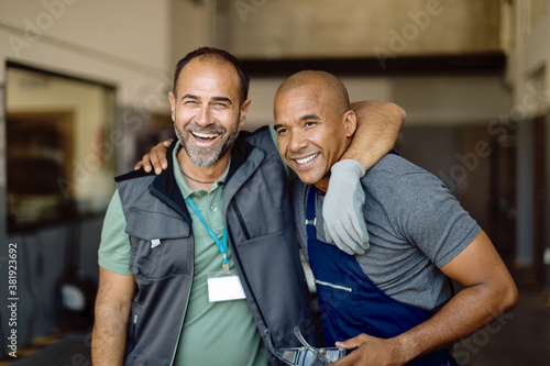 Fotografia Two happy workers at auto repair shop.