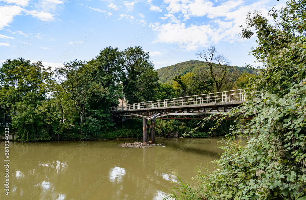 Beautiful mountain range with a bridge over the river in summer against a blue sky with clouds. blurry focus Beautiful mountain range with a bridge over the river in summer against a blue sky with clouds. blurry focus