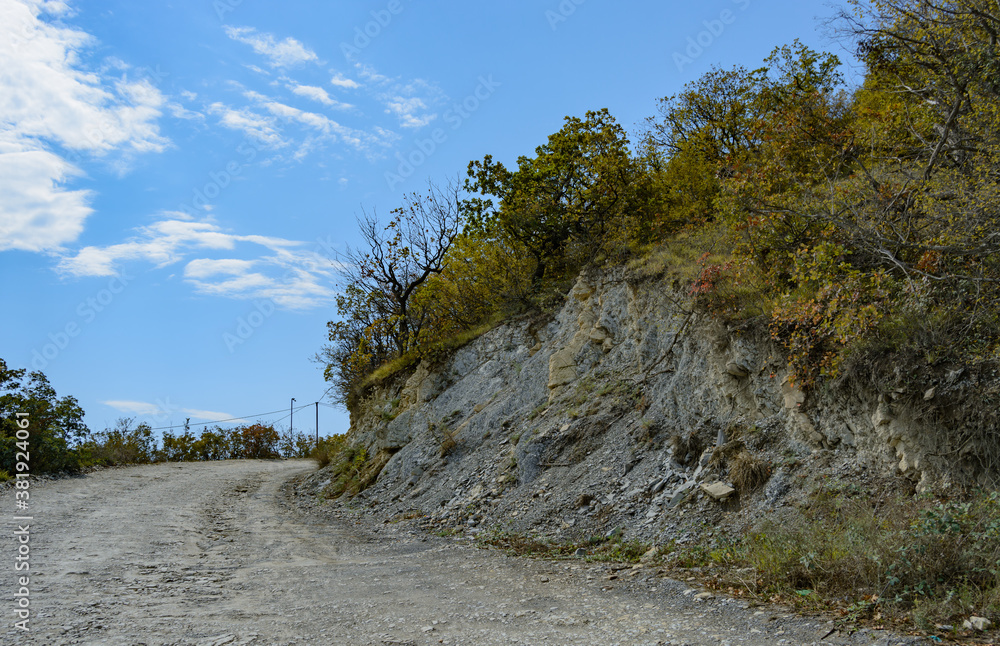 Highway along a beautiful mountain range in summer against a blue sky with clouds. blurry focus Highway along a beautiful mountain range in summer against a blue sky with clouds. blurry focus