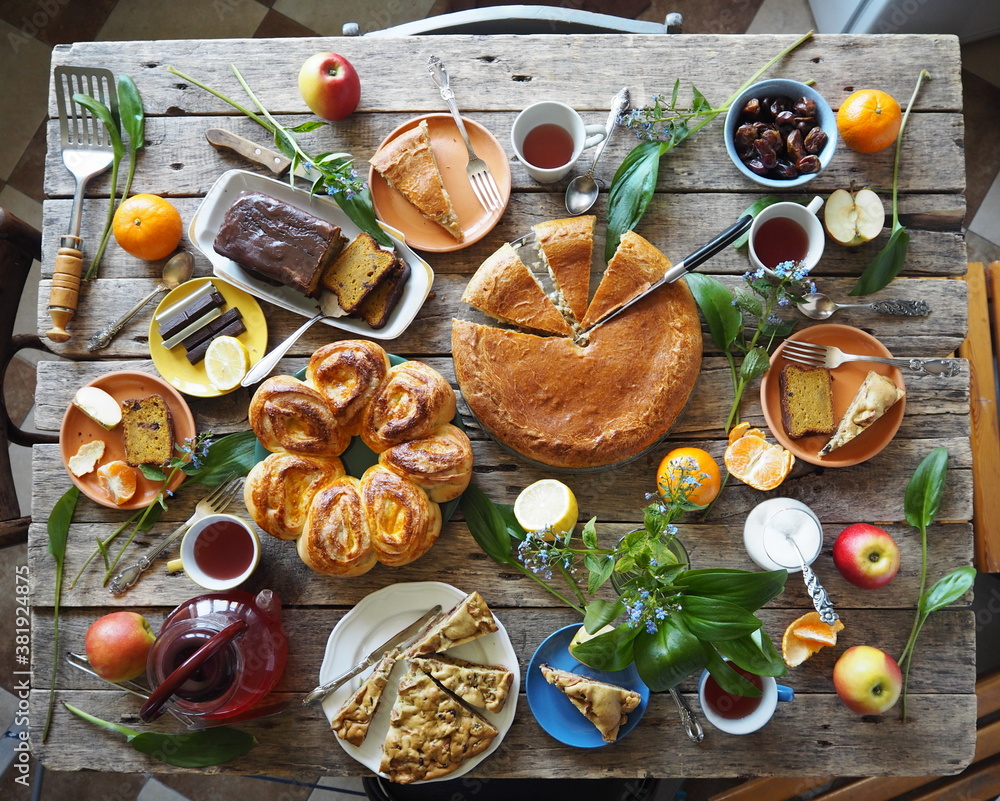 Festive meal on an ancient wooden table.A table with natural homemade cakes, fruits is ready to receive guests Festive meal on an ancient wooden table.A table with natural homemade cakes, fruits is ready to receive guests