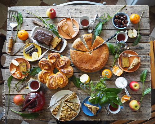 Festive meal on an ancient wooden table.A table with natural homemade cakes, fruits is ready to receive guests