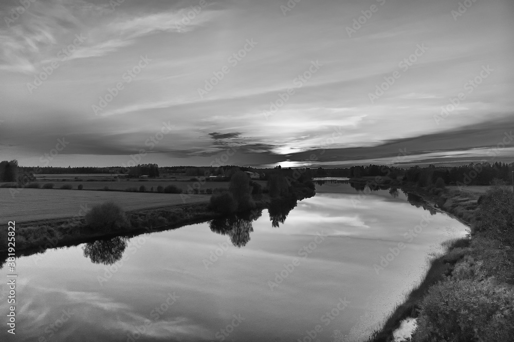 Fototapeta premium Sun Setting Over The River And Fields