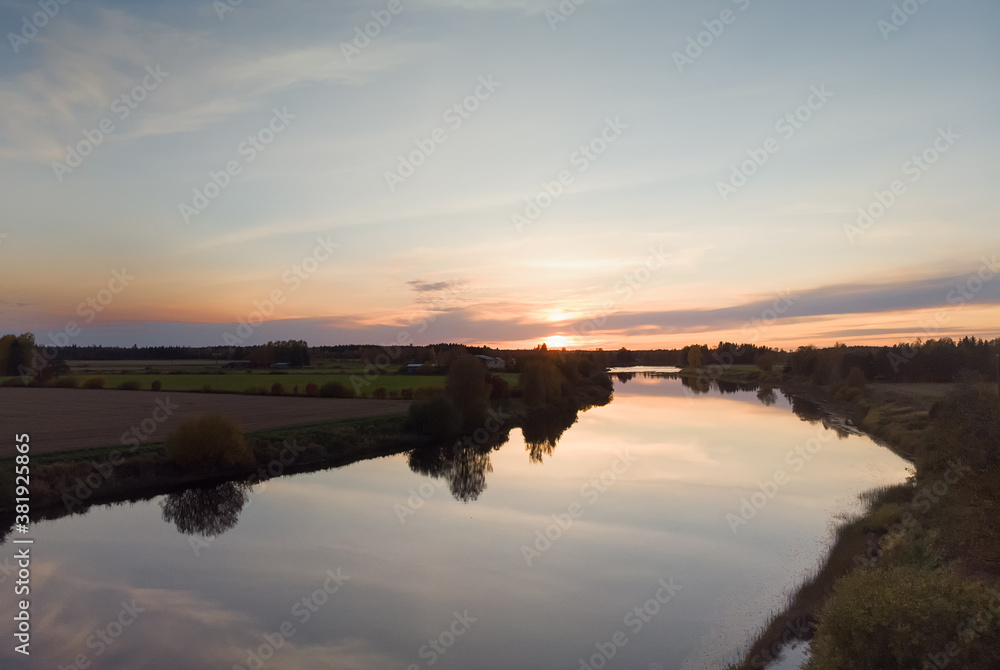Sun Setting Over The River And Fields