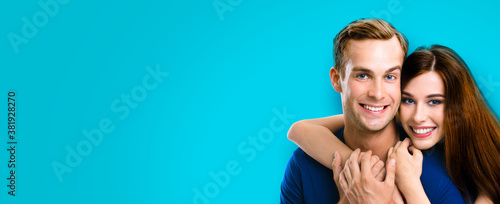 Happy young amorous couple. Portrait of embracing caucasian models at happy in love studio concept isolated against aqua blue marine color background. Man and woman posing together, copy space