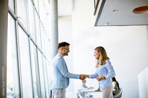 Young business partners making handshake in an office