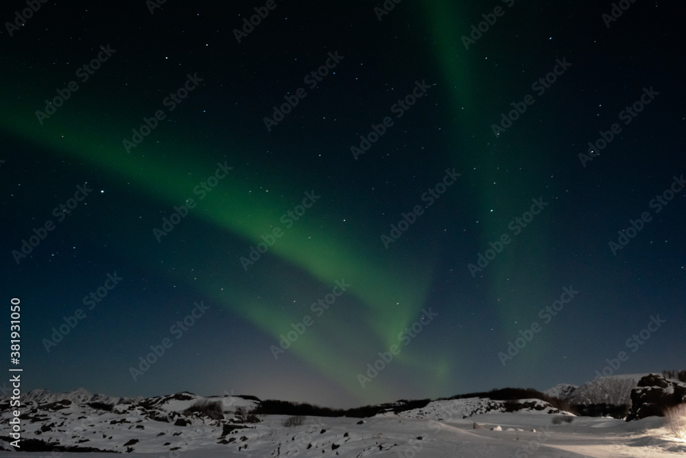 Beautiful Northern Lights green above mountain and ocean