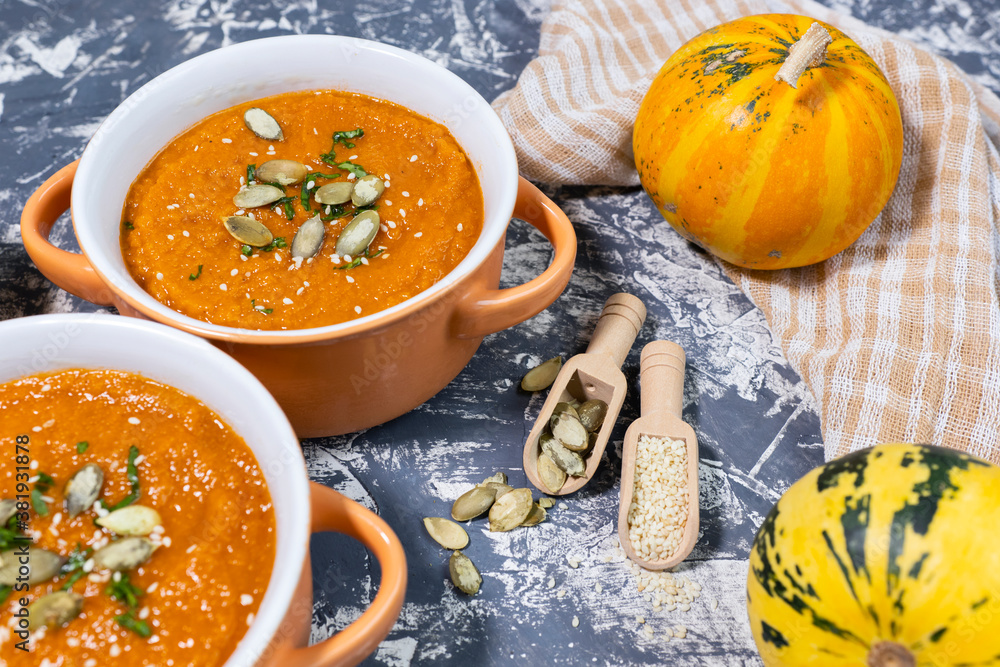 pumpkin cream soup with seeds, sesame and rucola on a grey background. Autumn flat lay. Top view. Cozy photo. pumpkin cream soup with seeds, sesame and rucola on a grey background. Autumn flat lay. Top view. Cozy photo.