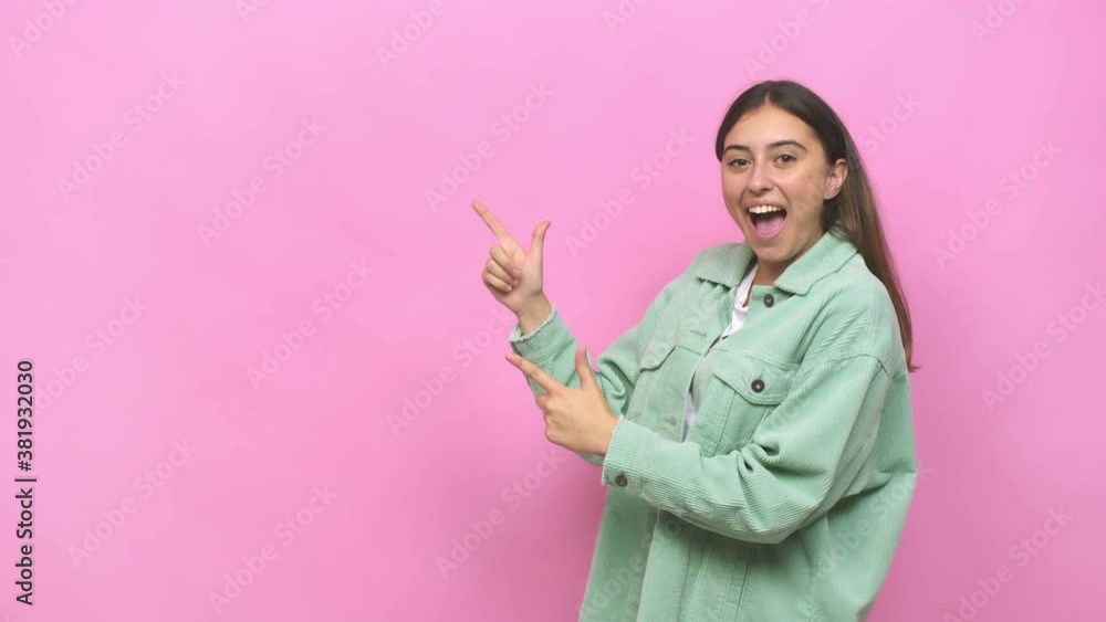 Young caucasian woman pointing with forefingers to a copy space, expressing excitement and desire Young caucasian woman pointing with forefingers to a copy space, expressing excitement and desire