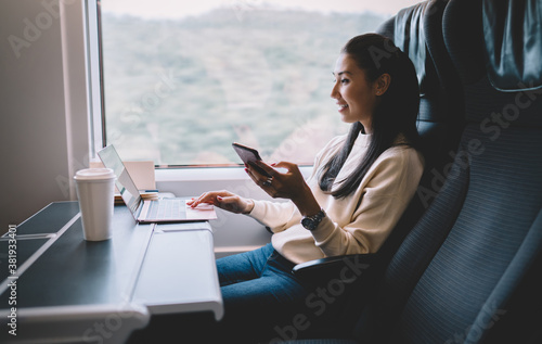 Young woman using smartphone in modern train photo