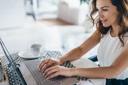 Young beautiful woman using a laptop computer at home photo