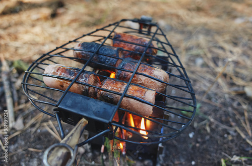 Sausages on the grill. Small bushcraft wood stove.