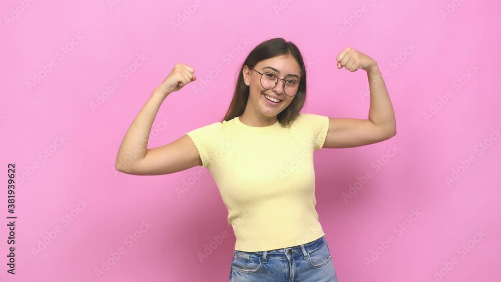 Young caucasian woman showing strength gesture with arms, symbol of feminine power Young caucasian woman showing strength gesture with arms, symbol of feminine power
