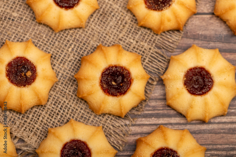 Homemade pastry cookies with jam on a background of homespun fabric with a rough texture, close-up, selective focus. Homemade pastry cookies with jam on a background of homespun fabric with a rough texture, close-up, selective focus.