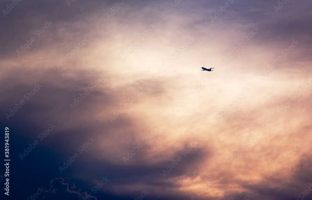 Avion volando entre nubes al atardecer